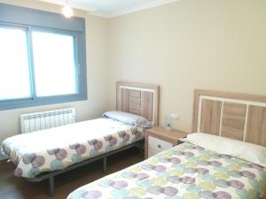 1 Schlafzimmer mit 2 Betten und 2 Fenstern in der Unterkunft Apartamento Villa Clarita in Sanxenxo