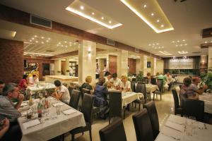 eine Gruppe von Personen, die in einem Restaurant an Tischen sitzen in der Unterkunft Hotel Ellena in Herceg-Novi