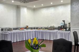 długi biały stół z kwiatami w pokoju w obiekcie Hotel i Restauracja Bona w mieście Sanok
