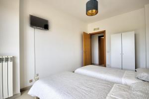 - une chambre avec 2 lits et une télévision murale dans l'établissement Appartamento Oceano, à Polignano a Mare