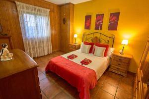 a bedroom with a large bed with red sheets and red blankets at Casa Mami Yaya in Firgas
