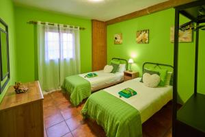 Casa Mami Yaya في Firgas: غرفة خضراء بسريرين مع جدران خضراء