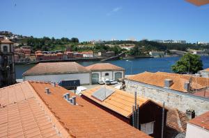 a view of roofs of buildings and a river at Alfandega Apartments in Porto