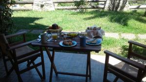 a table with food and drinks on it with two chairs at Lithoktisto in Limnionas
