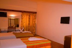 a hotel room with two beds and a television at Cleopatra Hotel in Aswan