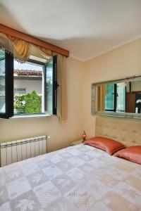 ein Schlafzimmer mit einem großen Bett und zwei Fenstern in der Unterkunft Apartments Holiday Lux in Sutomore
