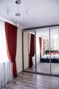 克列緬丘格的住宿－Rosy，一间卧室配有红色窗帘和镜子