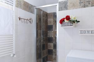 baño con ducha, aseo y flores en La Casa di Anetì, en Dolceacqua