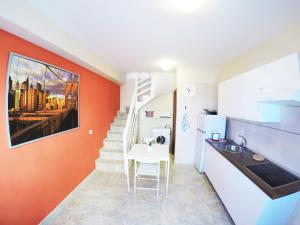 een keuken met een oranje muur en een witte tafel bij Carta Apartment in San Andrés in San Andrés