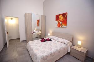 a bedroom with a bed and a painting on the wall at Casa Vignale in Avola