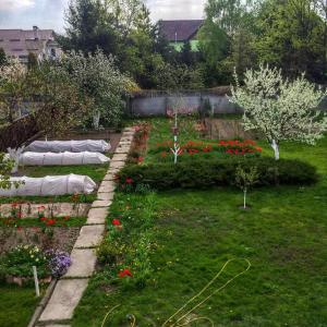 un jardín con camas de flores en un patio en Guest house on Ivana Franka en Novyye Petrovtsy