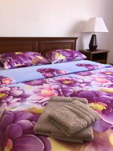 a bedroom with a bed with purple flowers on it at Guest house on Ivana Franka in Novyye Petrovtsy