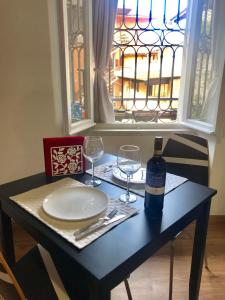 einen Tisch mit einer Flasche Wein und zwei Gläsern in der Unterkunft Appartamenti I Giardini Di Villa Melzi in Bellagio