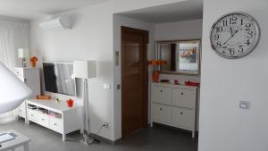 a living room with a clock on the wall and a tv at Sotavento Las Terrazas II, La Tejita in La Tejita
