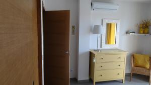 a bedroom with a door and a dresser and a mirror at Sotavento Las Terrazas II, La Tejita in La Tejita