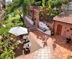 an aerial view of a house with an umbrella and tables at B&B Villa Vittoria in Giardini Naxos
