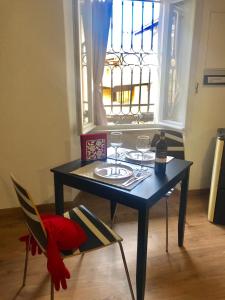 a table and chairs with wine glasses and a window at Appartamenti I Giardini Di Villa Melzi in Bellagio