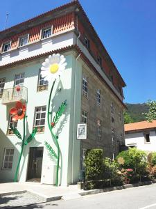um edifício com uma flor pintada ao lado dele em Hotel Central Jardim no Gerês
