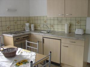 a kitchen with a sink and a stove and a table at Ferienwohnung Lindlar in Lindlar