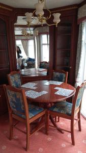 una sala da pranzo con tavolo e sedie in legno di The Boat House Guesthouse a Boat of Garten