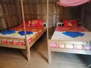 a room with two bunk beds in a house at Bee Bee's Chalets home stay and trekking in Banlung