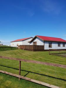 un granero blanco grande con techo rojo en Arabær Holiday Home, en Arabaer