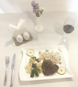 a plate of food on a table with a glass of wine at Medal hotel in Addis Ababa