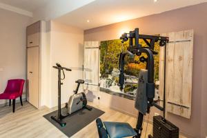 a gym with two exercise bikes in a room at Hostellerie Du Grand Duc in Gincla