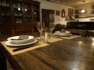 a wooden table with plates and wine glasses on it at apartment details Granaio in Pulicciano