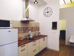 a kitchen with a white refrigerator and a clock on the wall at Miraflores 58 Apt - Private Parking Opt in Seville