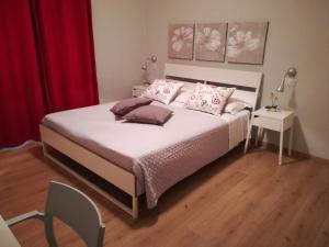 1 dormitorio con 1 cama blanca grande y cortinas rojas en Timeline camere in La Spezia en La Spezia