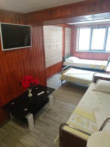 ポモリエにあるHouse Ogledaloviのベッド2台と壁掛けテレビが備わる客室です。