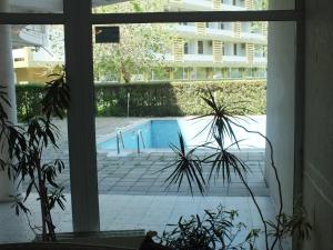 a view of a swimming pool from a window at SeaSide Piano Bar Apartament in Mamaia