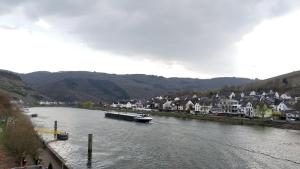 ein Boot, das einen Fluss hinunter in einer Stadt fährt in der Unterkunft Villa Cella in Zell an der Mosel