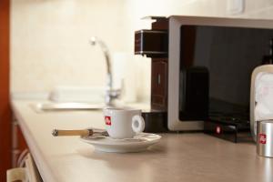 una taza de café sentada en un mostrador junto a un monitor en LUXURY STUDIO in Xanthi, en Xanthi