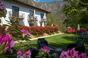 ein Haus mit Garten und Blumen davor in der Unterkunft Hotel Al Fiume in Tegna