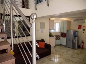 a living room with a couch and a kitchen at Zion Place in Ikeja