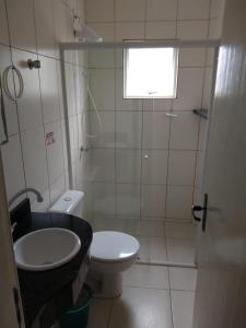 y baño con aseo blanco y lavamanos. en Residencial Melfi 3 Ap.8 Fundos, en Bombinhas