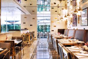 a restaurant with wooden tables and chairs and windows at Tamani Marina Hotel & Apartments in Dubai