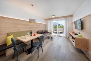 uma sala de jantar e sala de estar com mesa e cadeiras em Appartement-Hotel Anthea em Tirolo