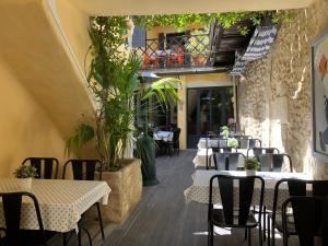 restauracja ze stołami i krzesłami oraz balkonem w obiekcie Le Sommeil des Fées w mieście Saint-Rémy-de-Provence