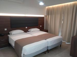 een slaapkamer met een groot bed en een televisie bij Livas Hotel Apartments in Protaras