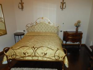 タルクイーニアにあるPalazzo Rosatiのベッドルーム1室(金製のベッドフレーム付)