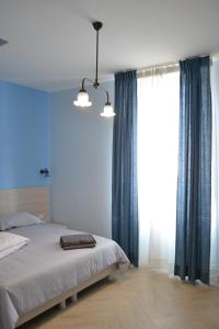 una camera con letto e tende blu di La stanza dell'angolo a Maratea