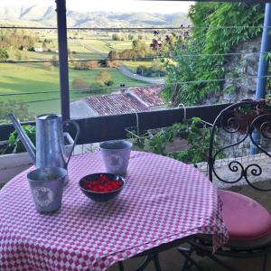 uma mesa com uma toalha de mesa rosa e uma taça de fruta em Le Pontin em Mane