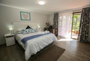 een slaapkamer met een groot bed en een glazen schuifdeur bij Farm View Guest House in East London