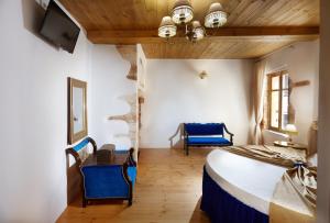 - une chambre avec un lit et des chaises bleues dans l'établissement Casa Perla Suites, à La Canée