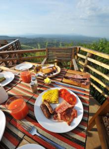 a plate of food with sausage and eggs on a table at Isunga Lodge in Kibale Forest National Park