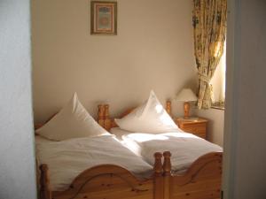 ein Schlafzimmer mit zwei Betten mit weißen Laken und Kissen in der Unterkunft Hotel Alt Wassenberg in Wassenberg