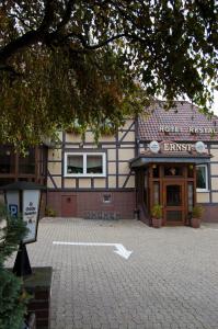 Hotel & Restaurant Ernst في Giesen: مبنى امامه مواقف من الطوب